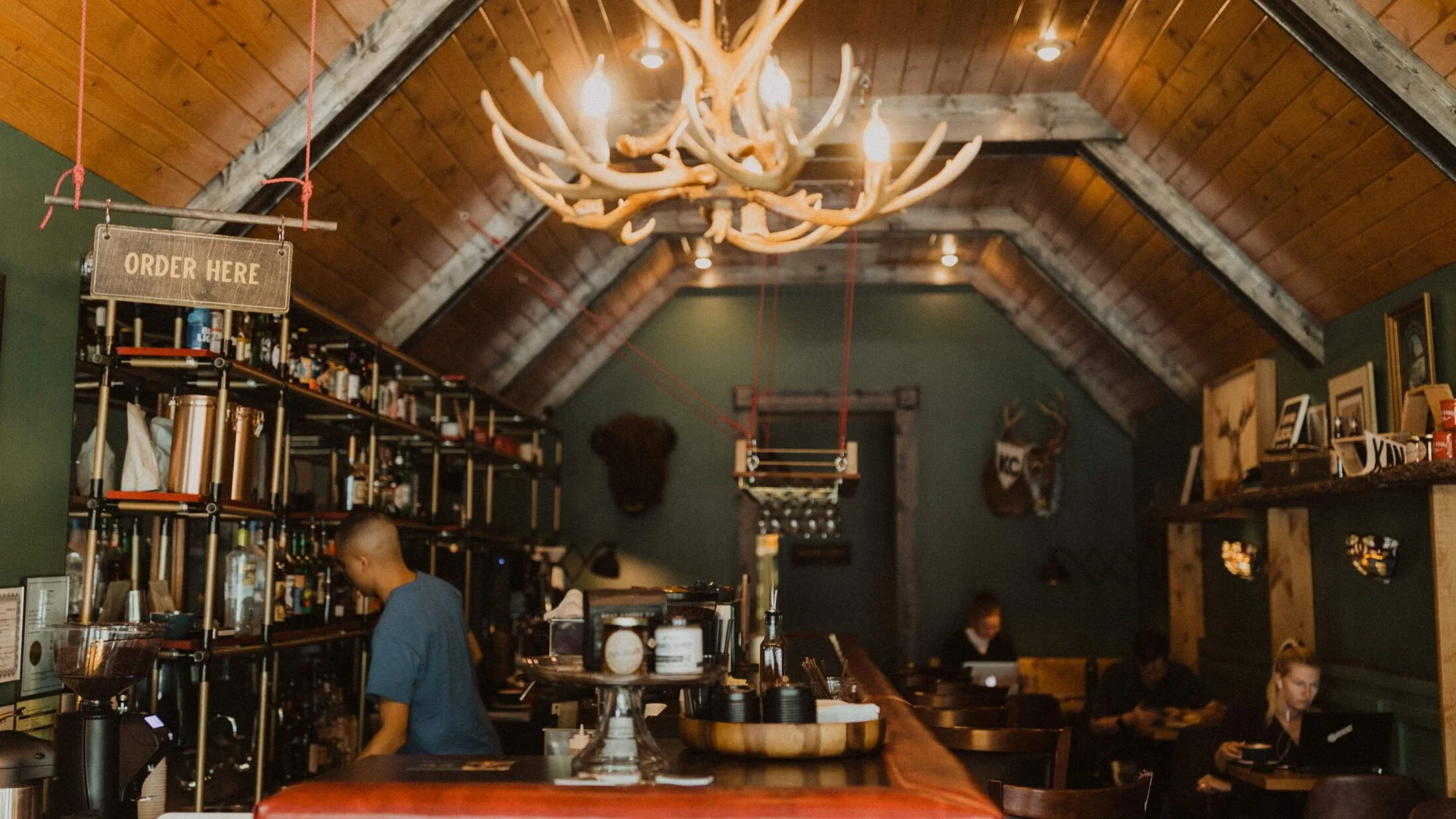 The bar and buffalo mount inside Front Range Fairway, under the antler chandelier