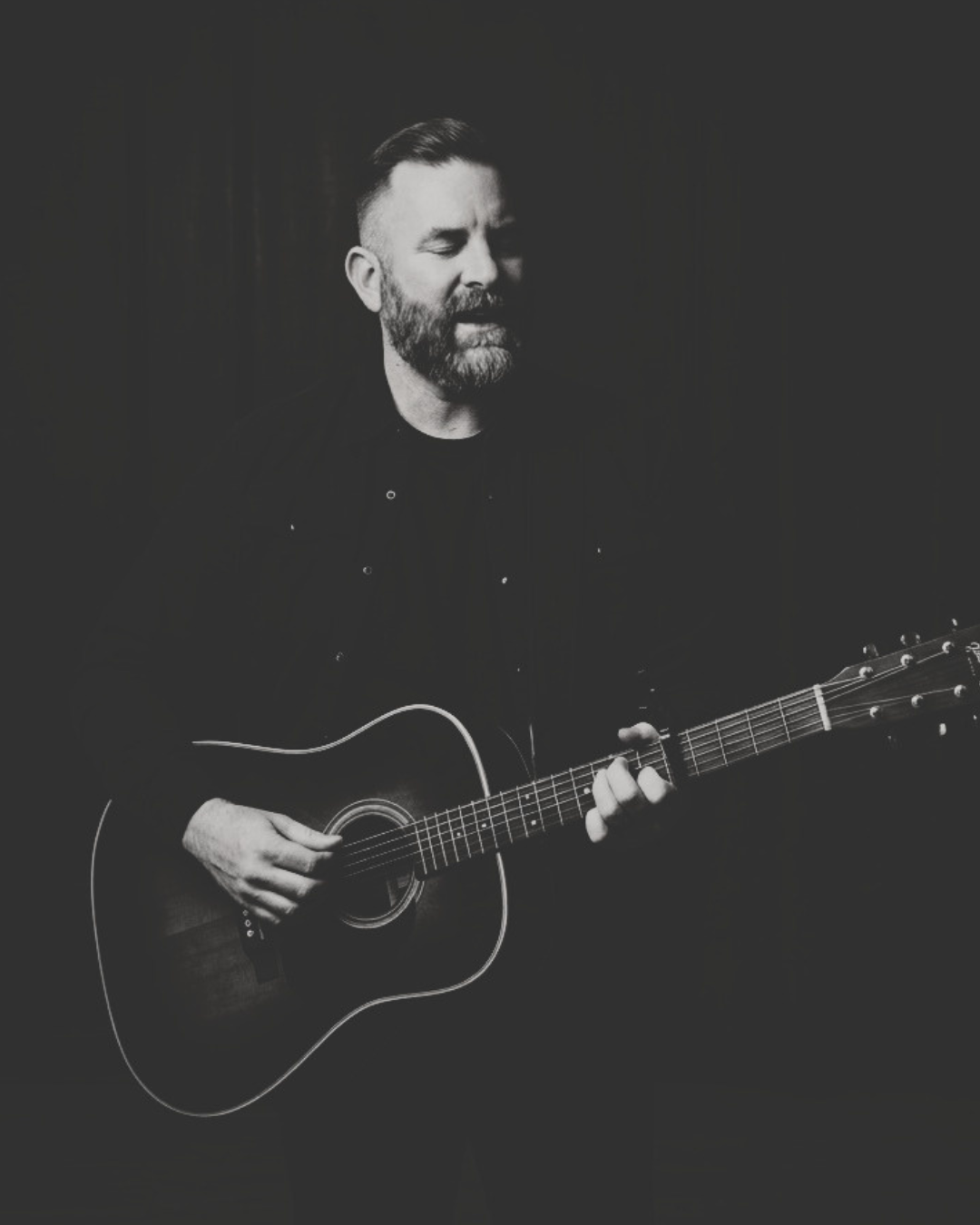 Josh Smith singing and playing acoustic guitar