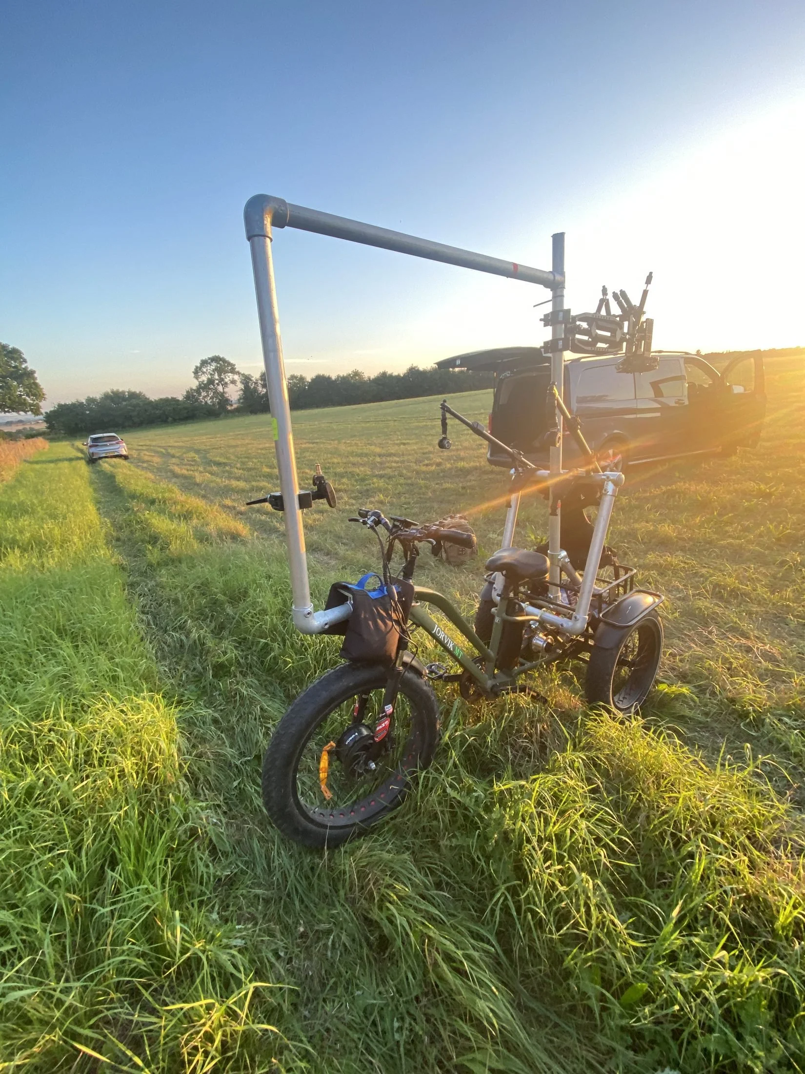 Electric camera trike in a field at sunset