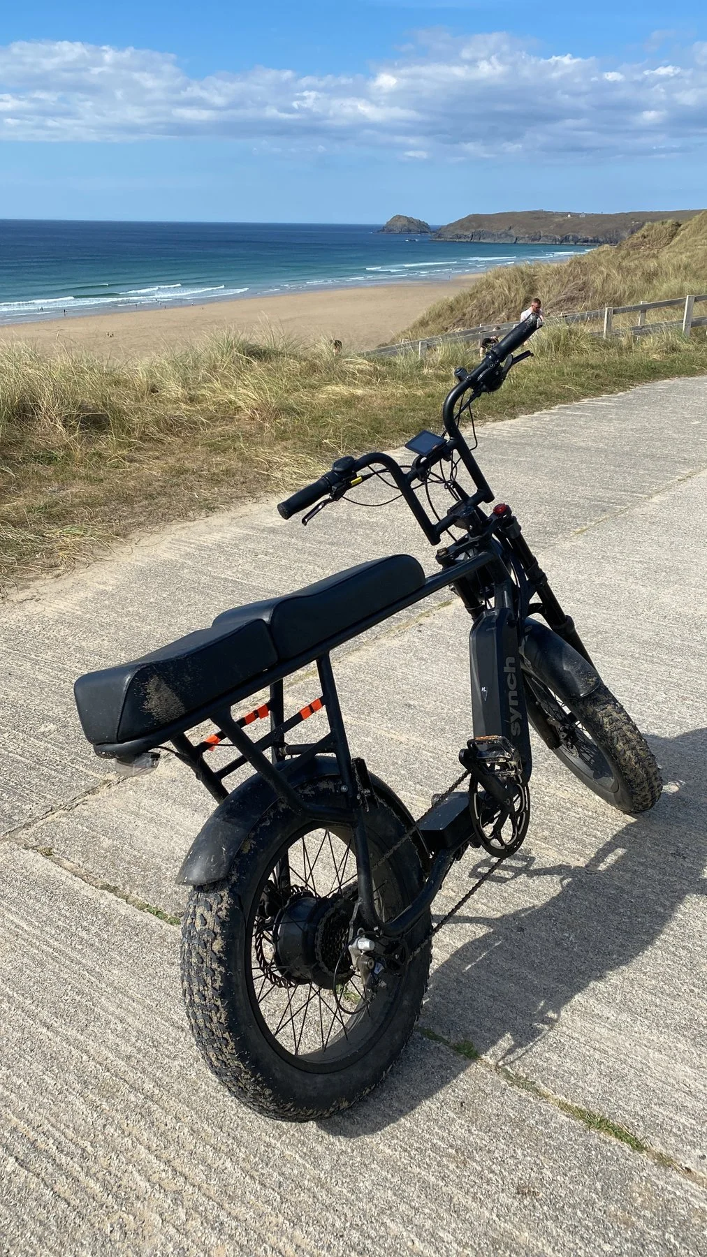 Custom fat-tyre electric tracking bike on a Cornish coast path above the beach