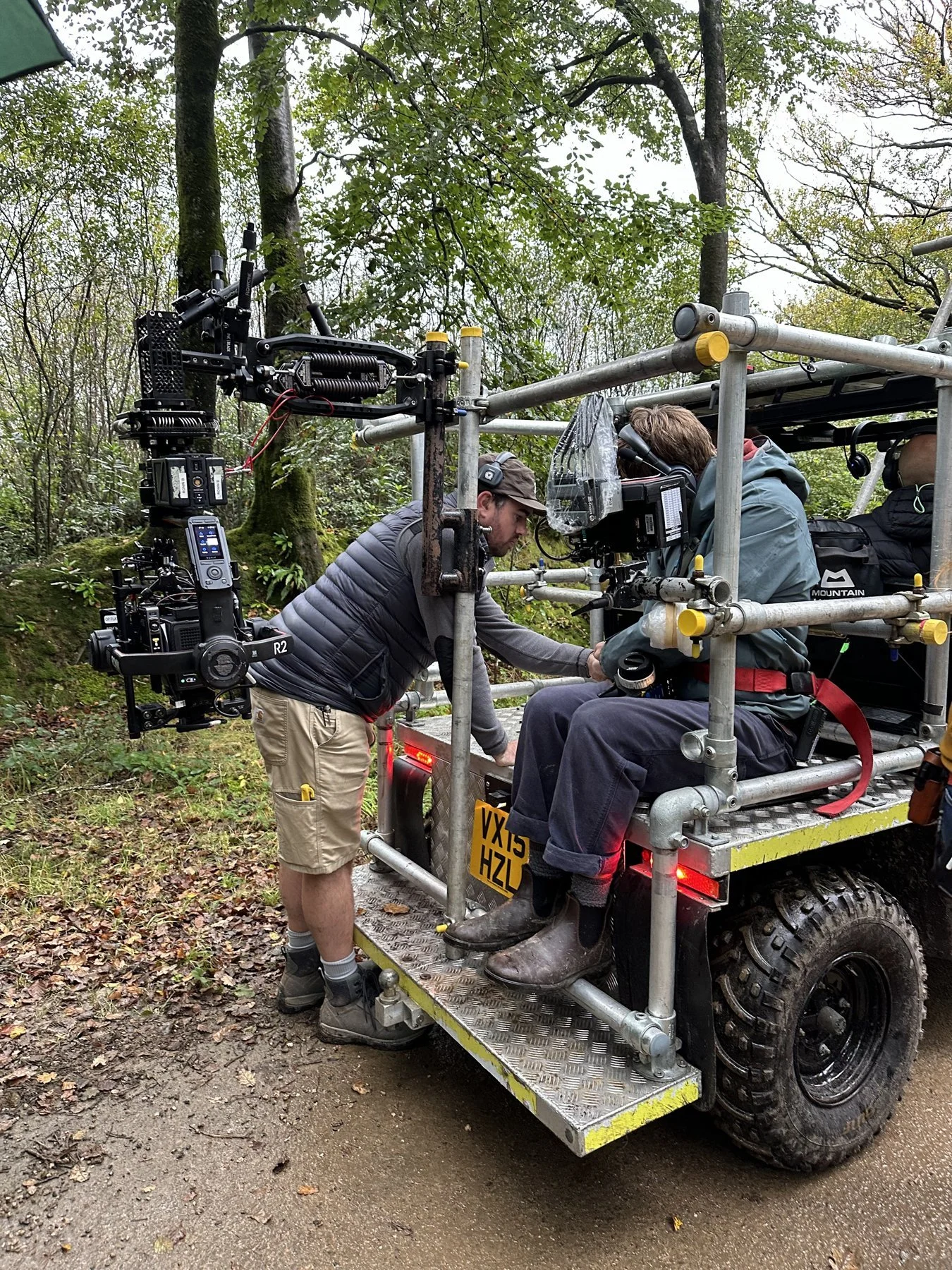 Electric quad rigged with a gimbal arm and crew seats on a woodland track