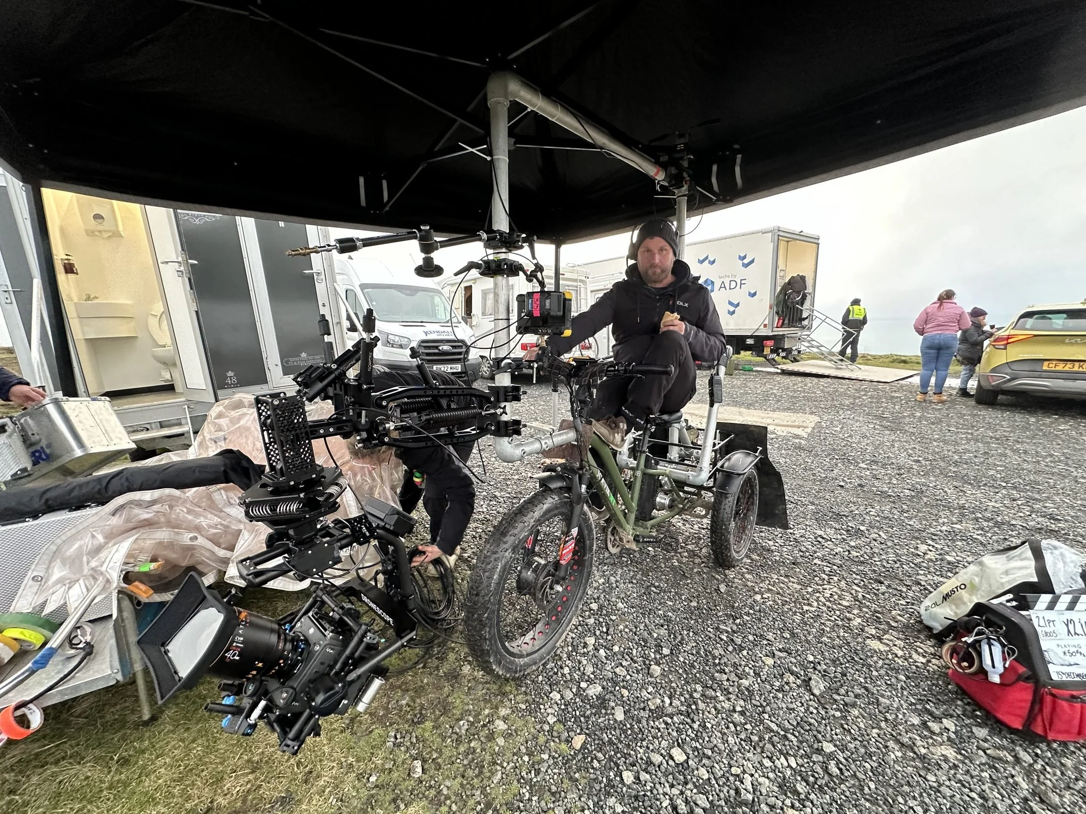 Electric cine-trike rigged with a cinema camera on a stabilised arm at a TV unit base