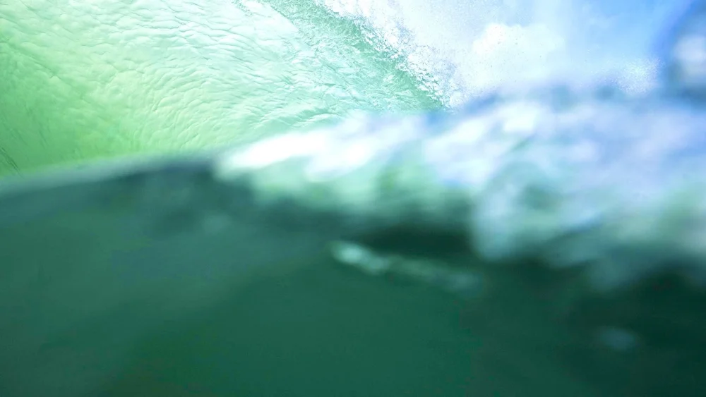 Split-level shot of a breaking wave, half above and half below the water