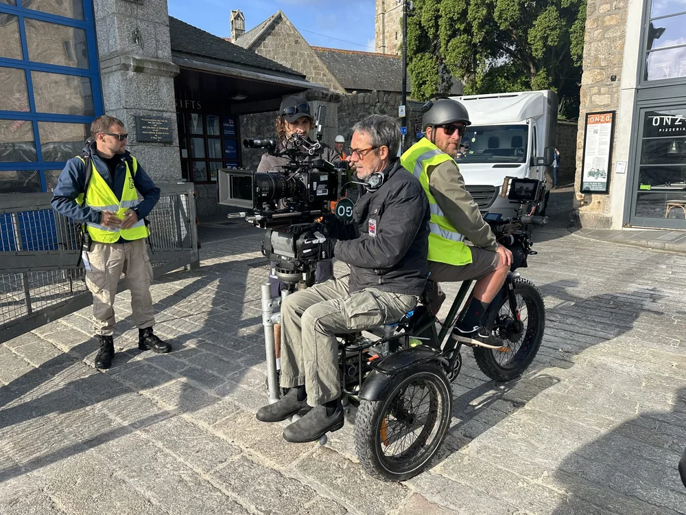 Camera operator with a cinema camera riding on the electric Cine-Trike