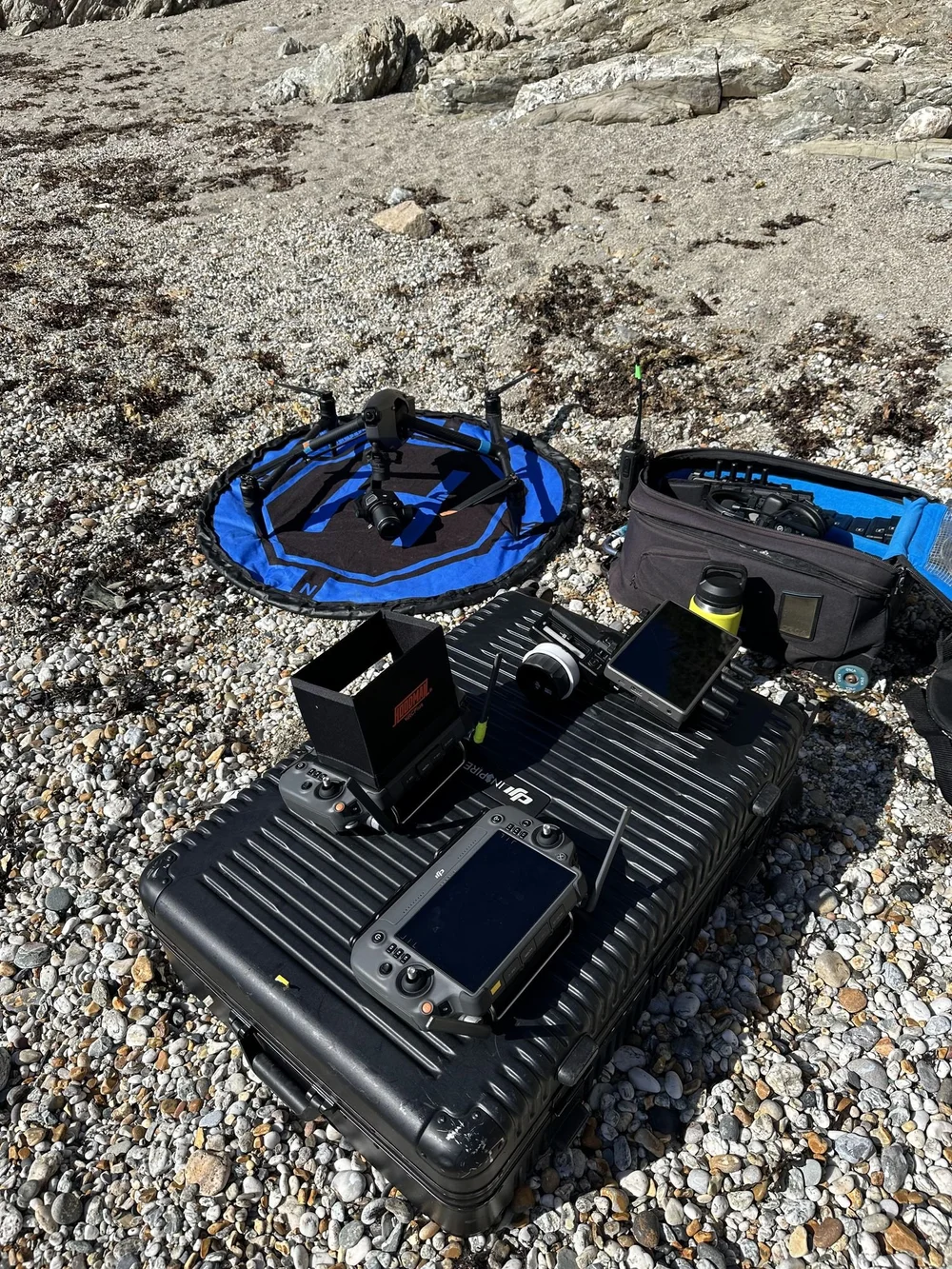 Inspire 3 drone kit laid out on a beach