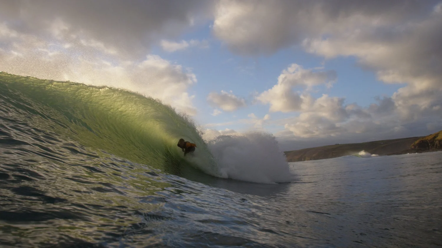Surfer in a green barrel in Cornwall, filmed from the water