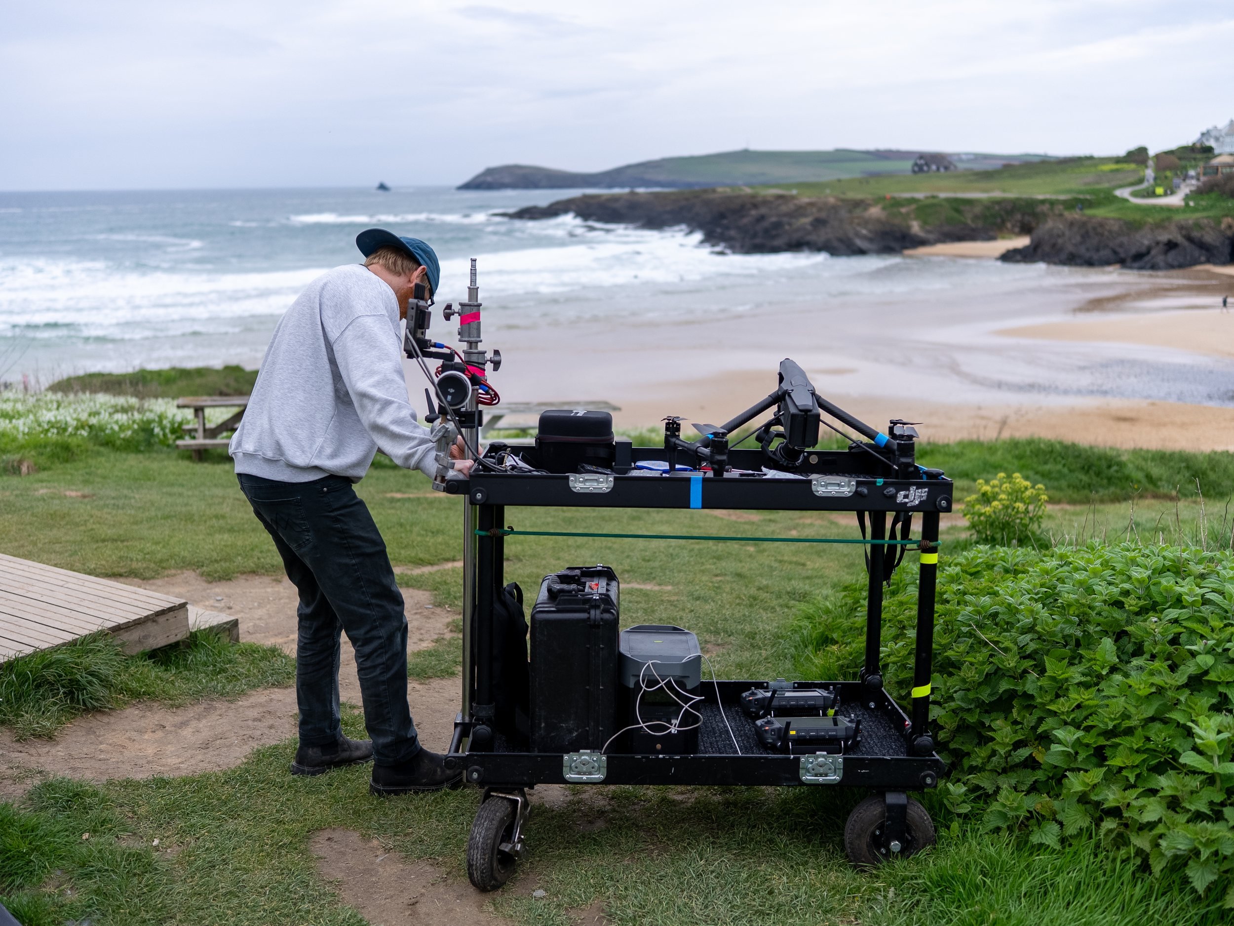 Drone crew working at the ground station cart above a beach on location