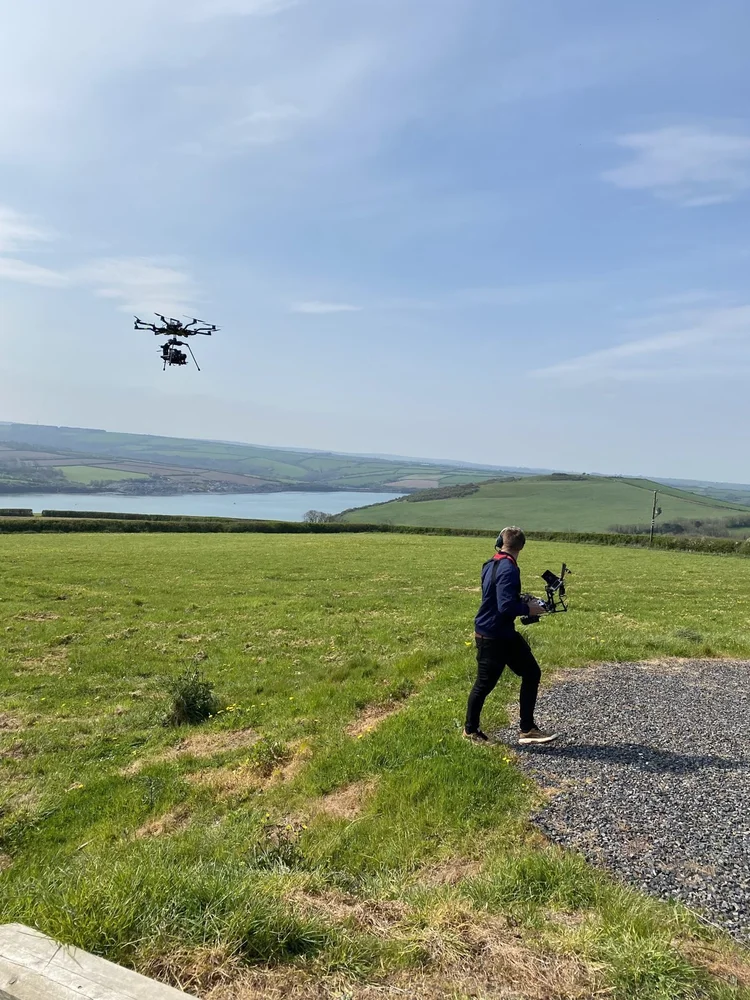 Alta 8 in flight over an estuary with the operator on the controls