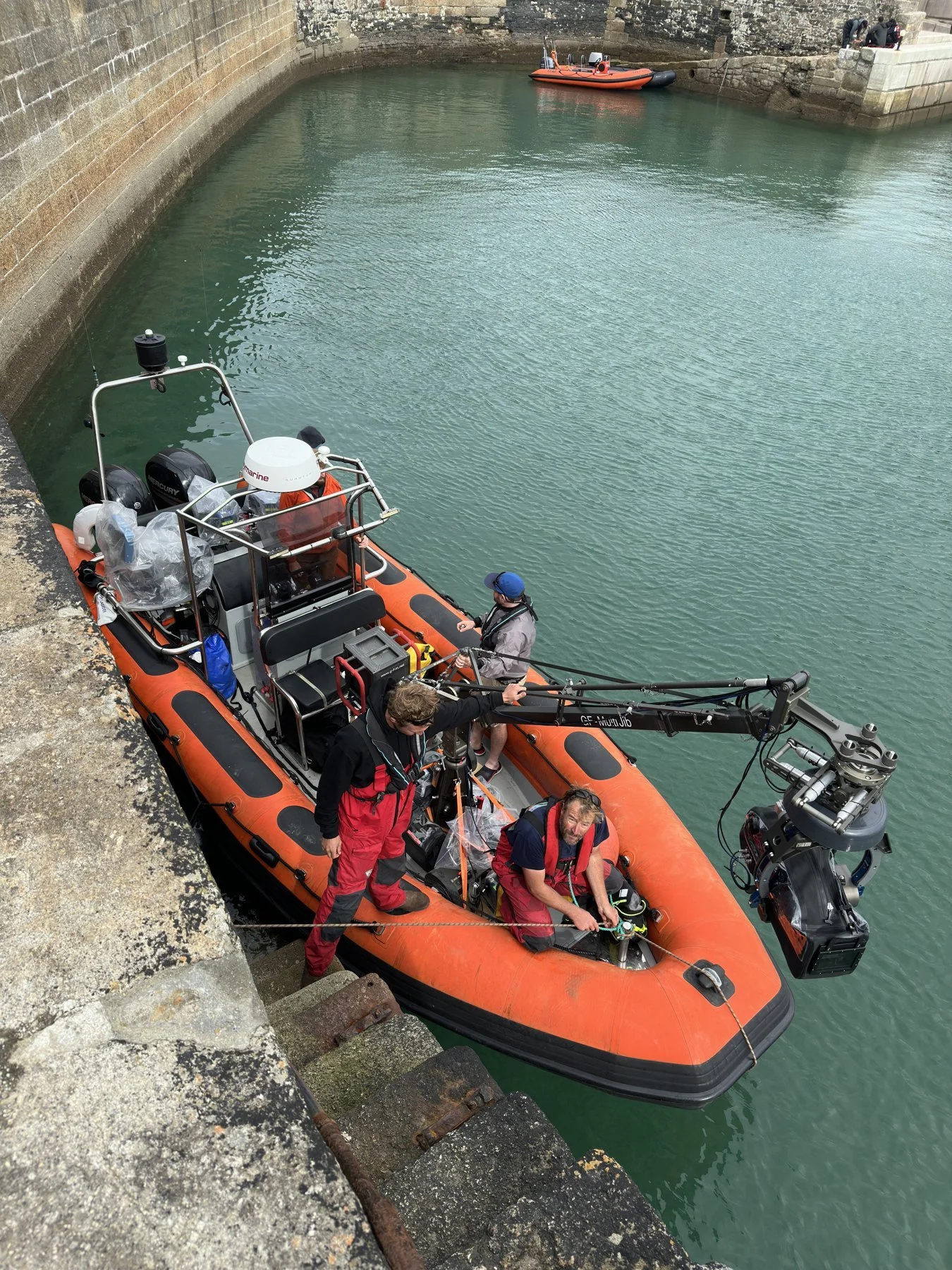 RIB in a harbour rigged with a jib arm and remote head, crew on board