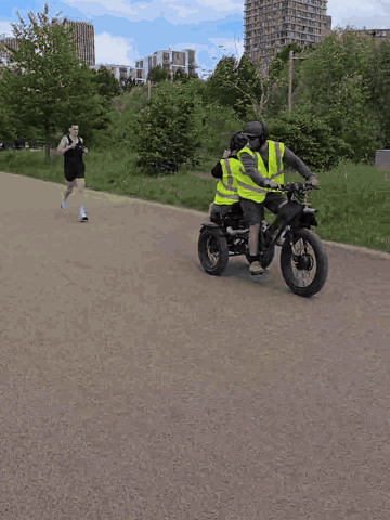 Cine-trike with a camera operator on the back tracking runners at a running event
