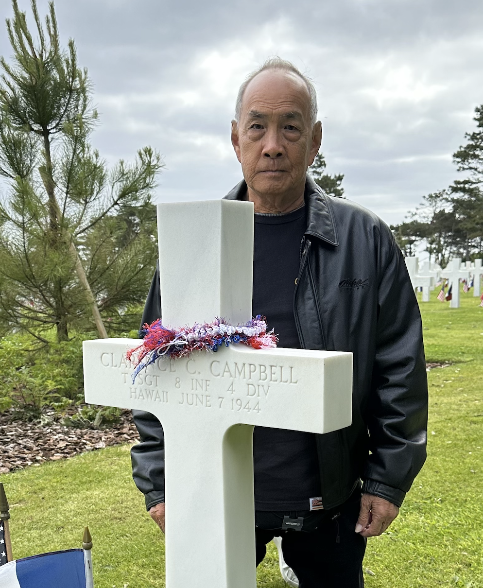 Placing a lei at the grave of a Hawaii soldier at the Normandy American Cemetery