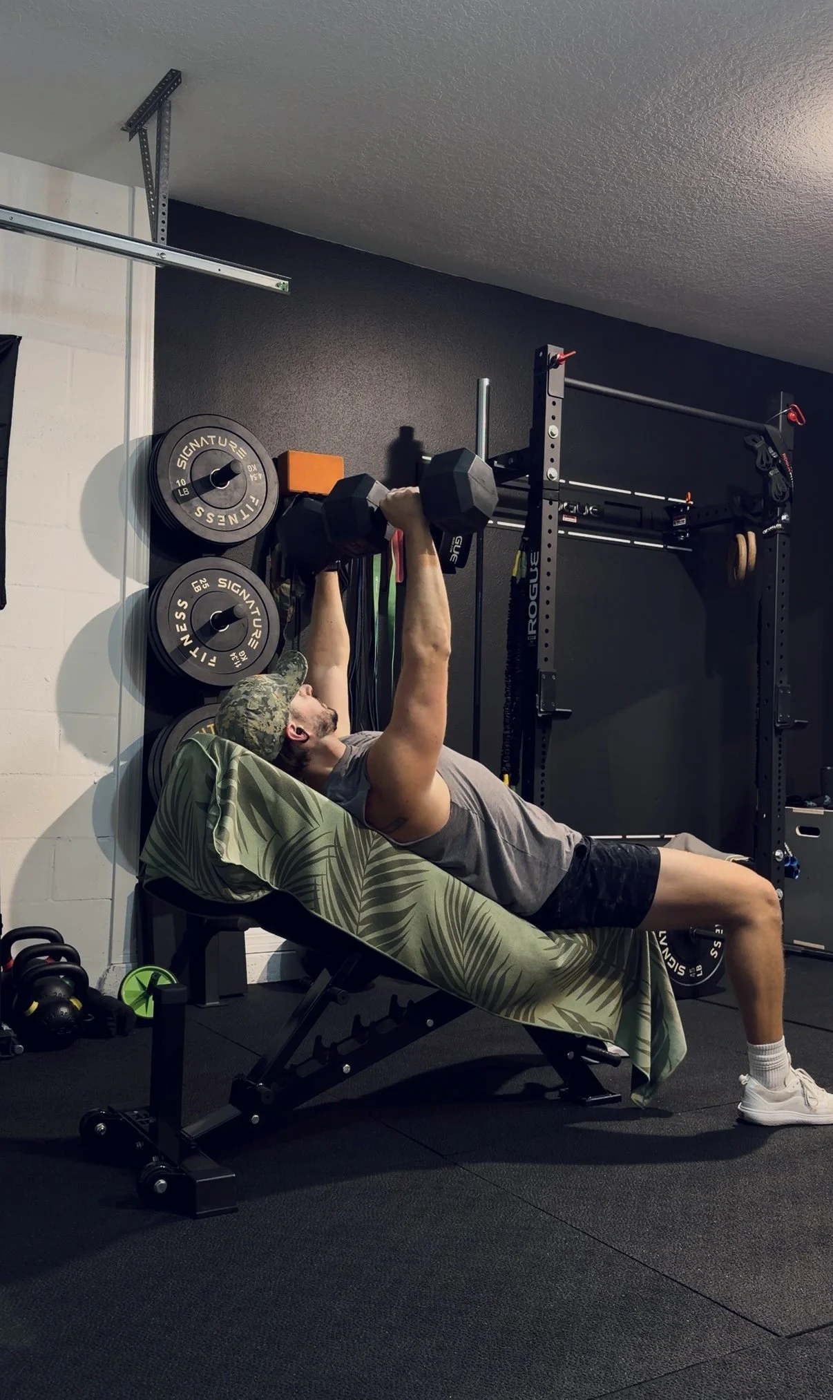Mitch pressing dumbbells on an incline bench in his garage gym
