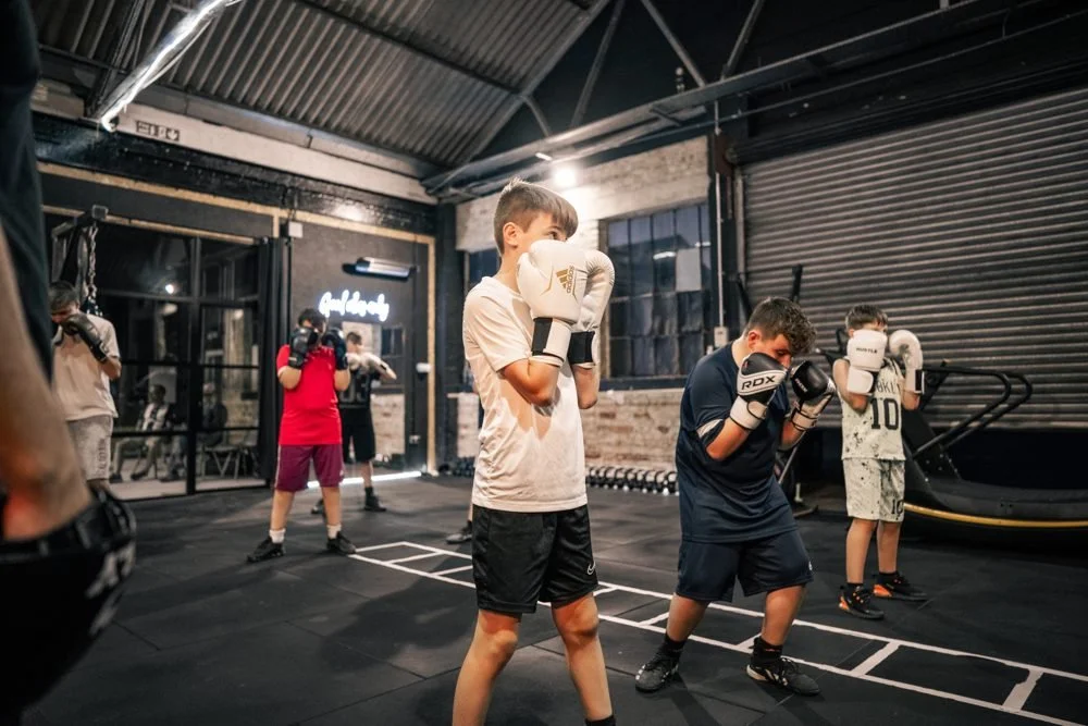 Kids in their guard stance during a Hustle junior boxing class