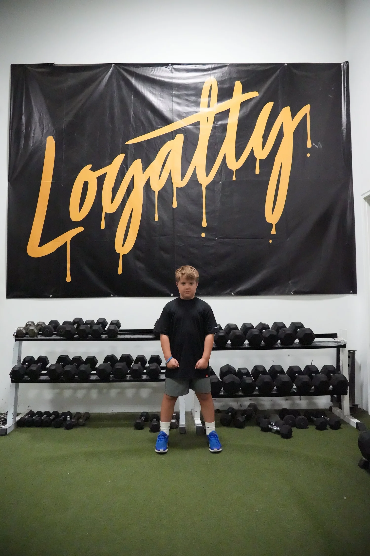 Young athlete standing under the gold Loyalty banner