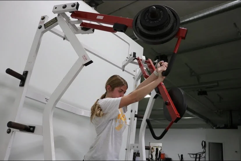 Athlete training on a plate-loaded press machine at the Gretna facility