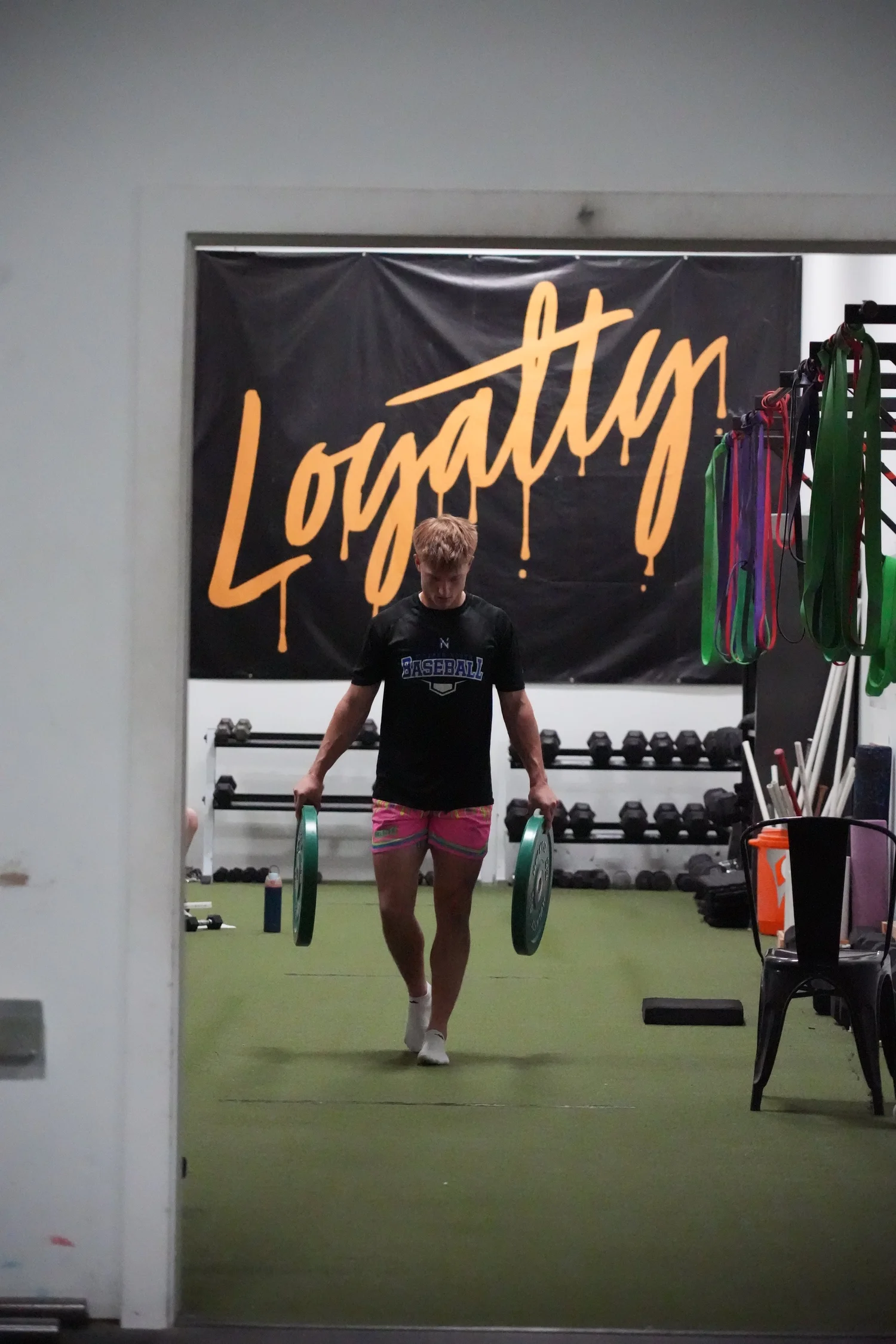 Athlete carrying plates in front of the Loyalty banner