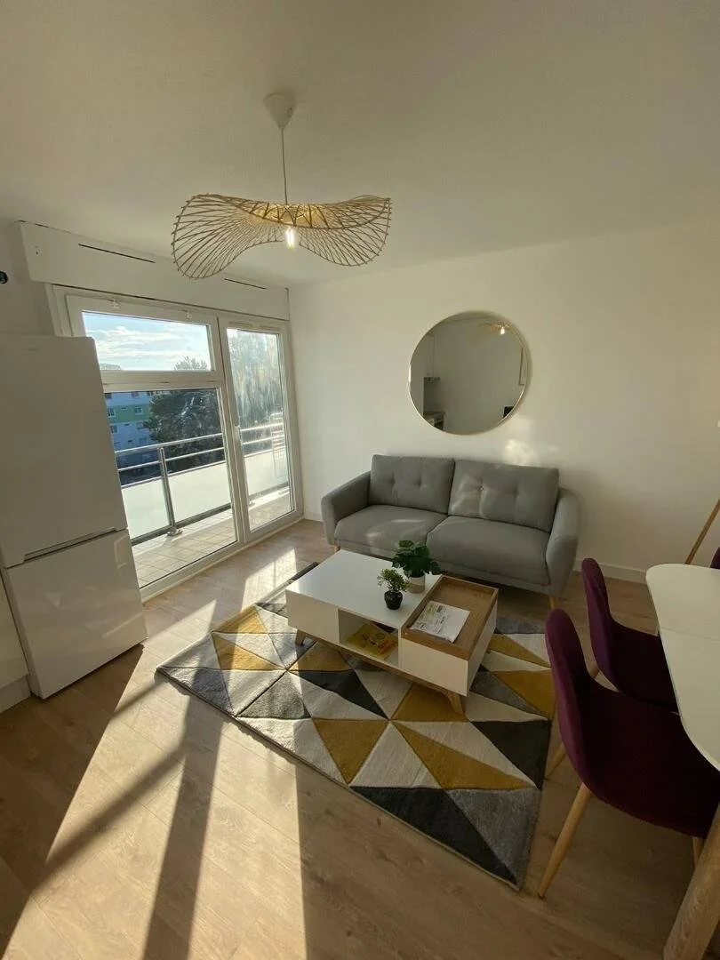 Séjour meublé d’une réalisation Start to Grow à Nantes, avec canapé, balcon et espace repas