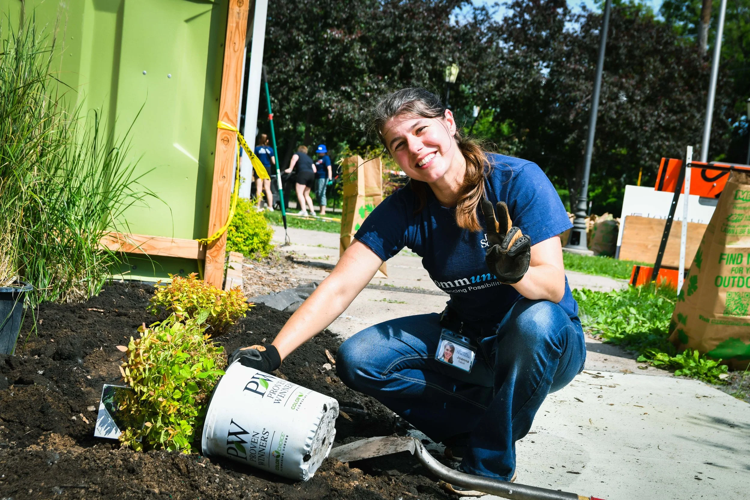 Boston Scientific posing while planting a plant at the front of the new CLUES building