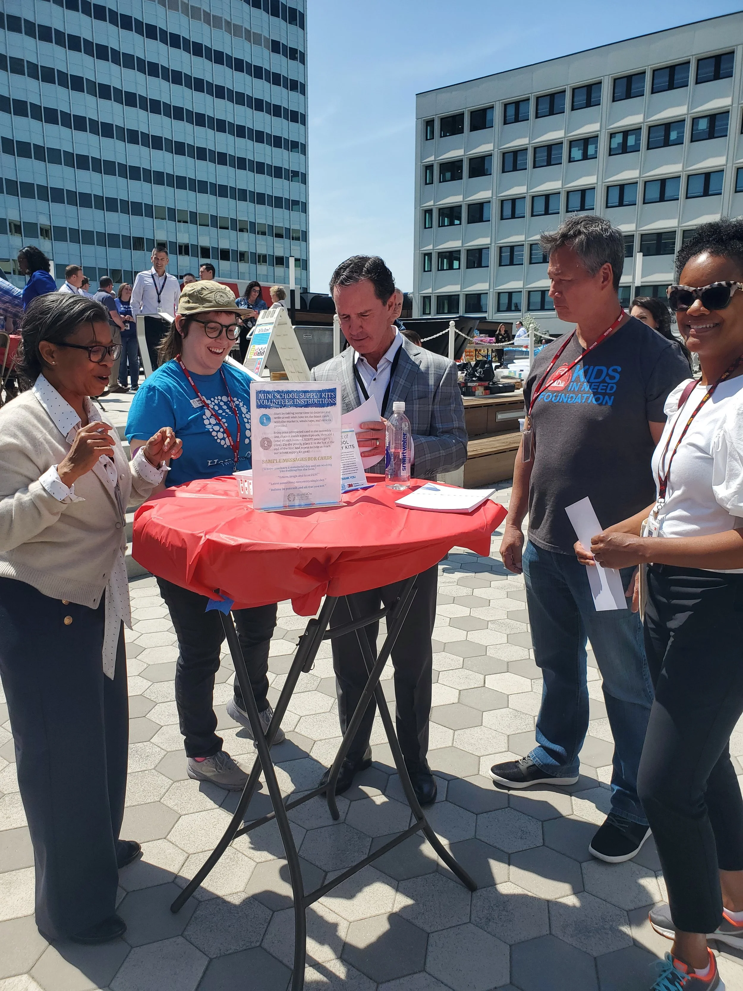 3M volunteers around a table talking with HandsOn Twin Cities team member about the project