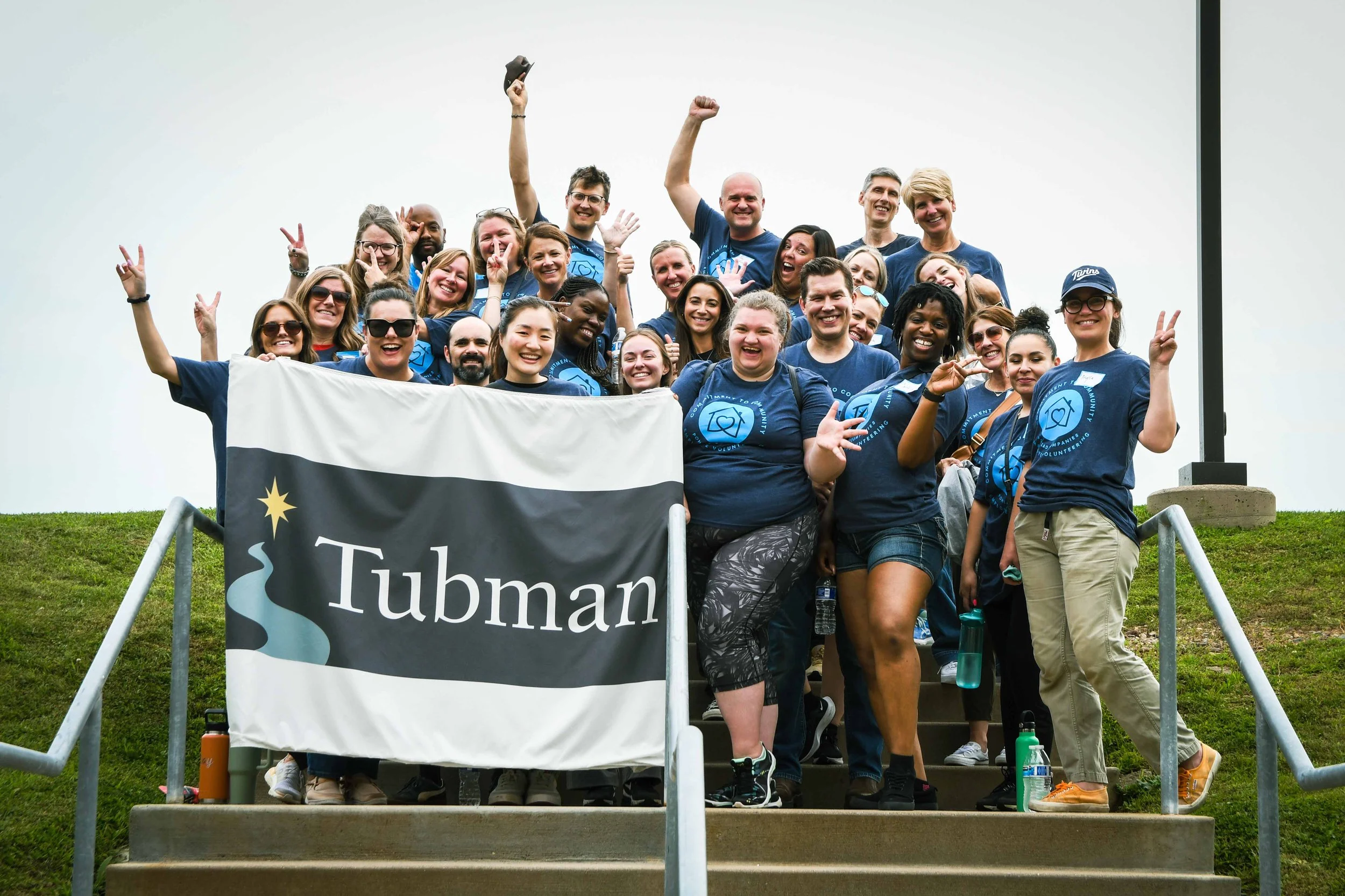 Pohlad volunteers holding Tubman's sign after completing their volunteer project