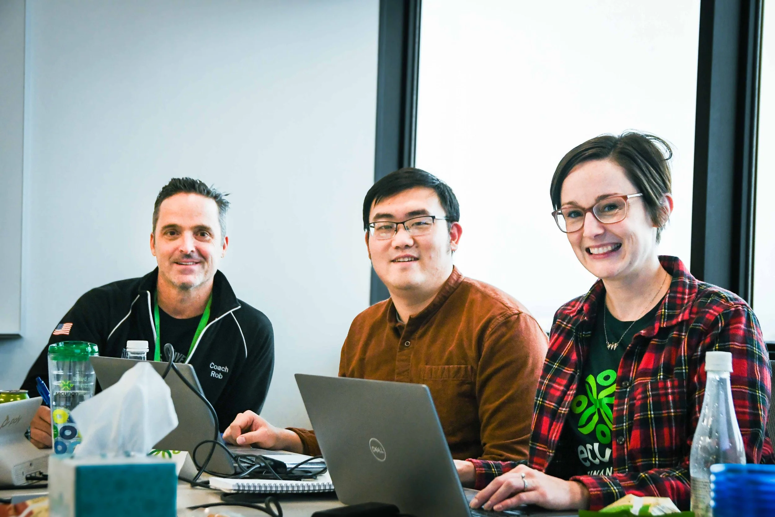 Securian volunteers in front of their laptops smiling at camera
