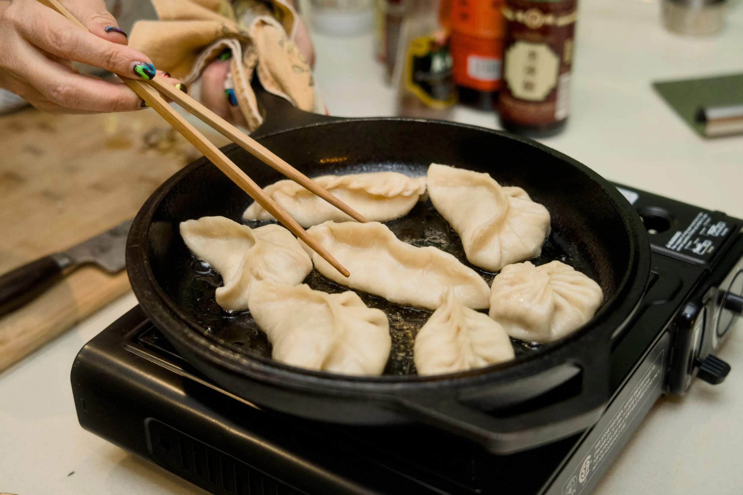 Hands making dumplings at Dash of Soy