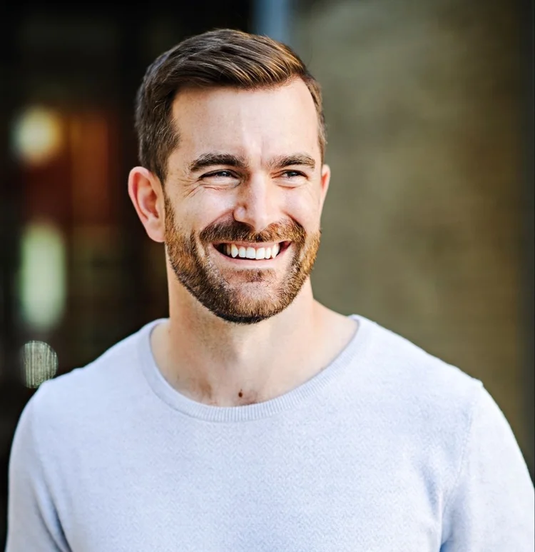 Dave Whiteside laughing, wearing a light grey sweater