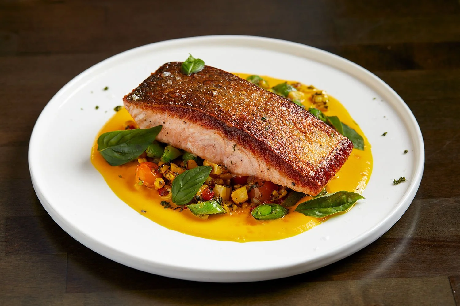 Crispy Kvarøy Arctic salmon over corn succotash and lobster bisque