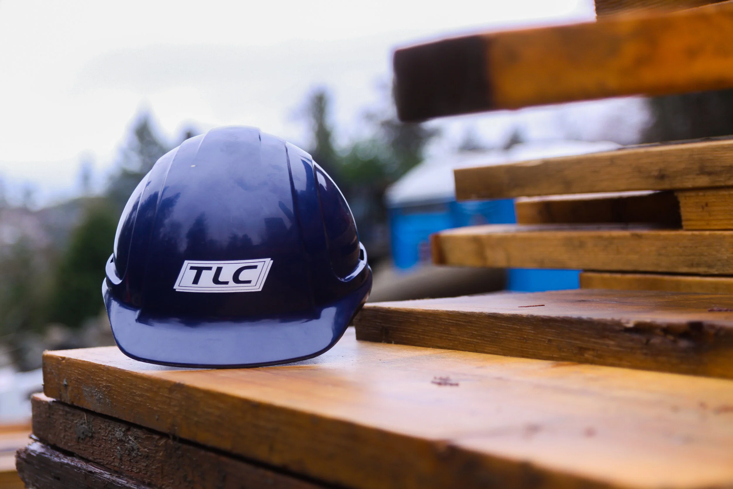 On-demand labour. TLC Hard hat on top of pieces of wood