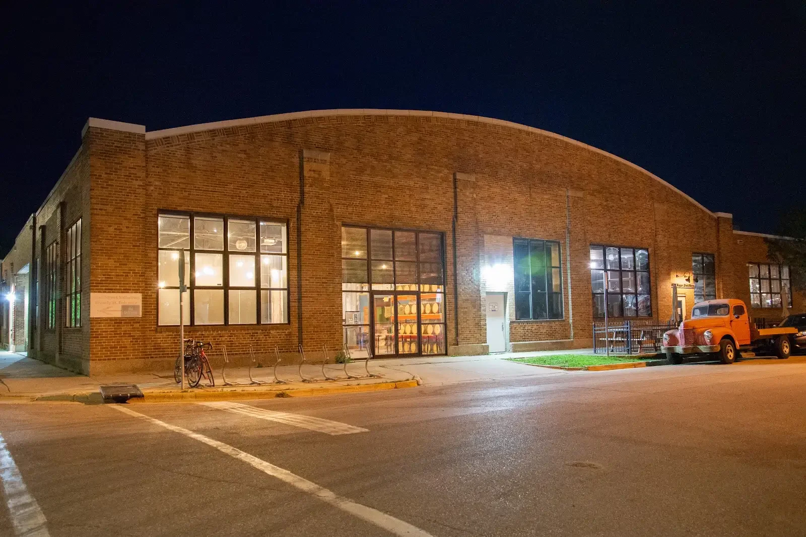 The Rickhouse at Old Sugar Distillery in Madison, with warm light glowing through its windows at night