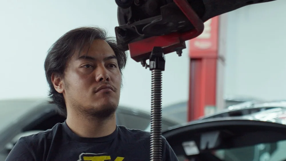 Close-up of a mechanic beside a vehicle lift