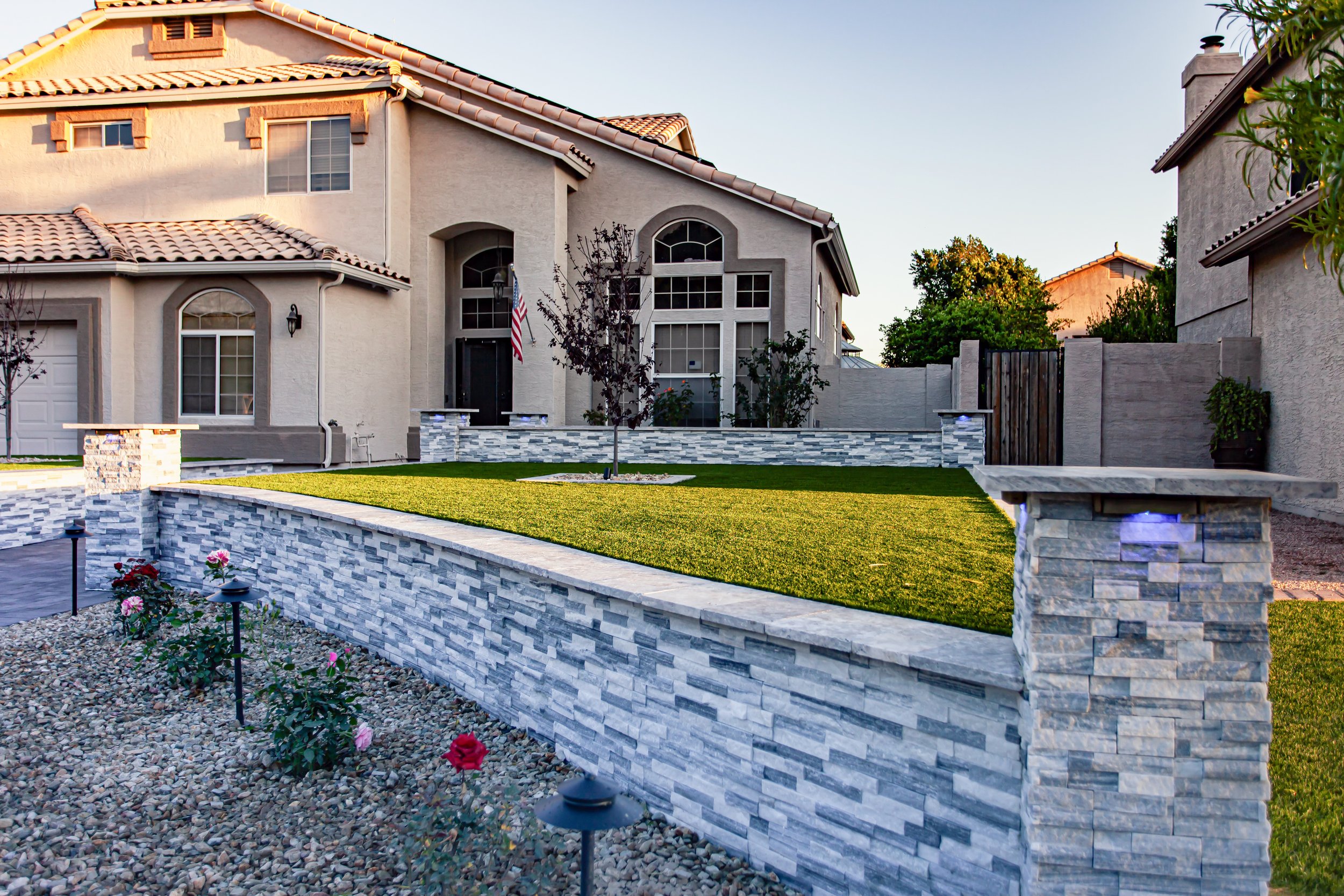 Simple backyard design featuring artificial turf and tree