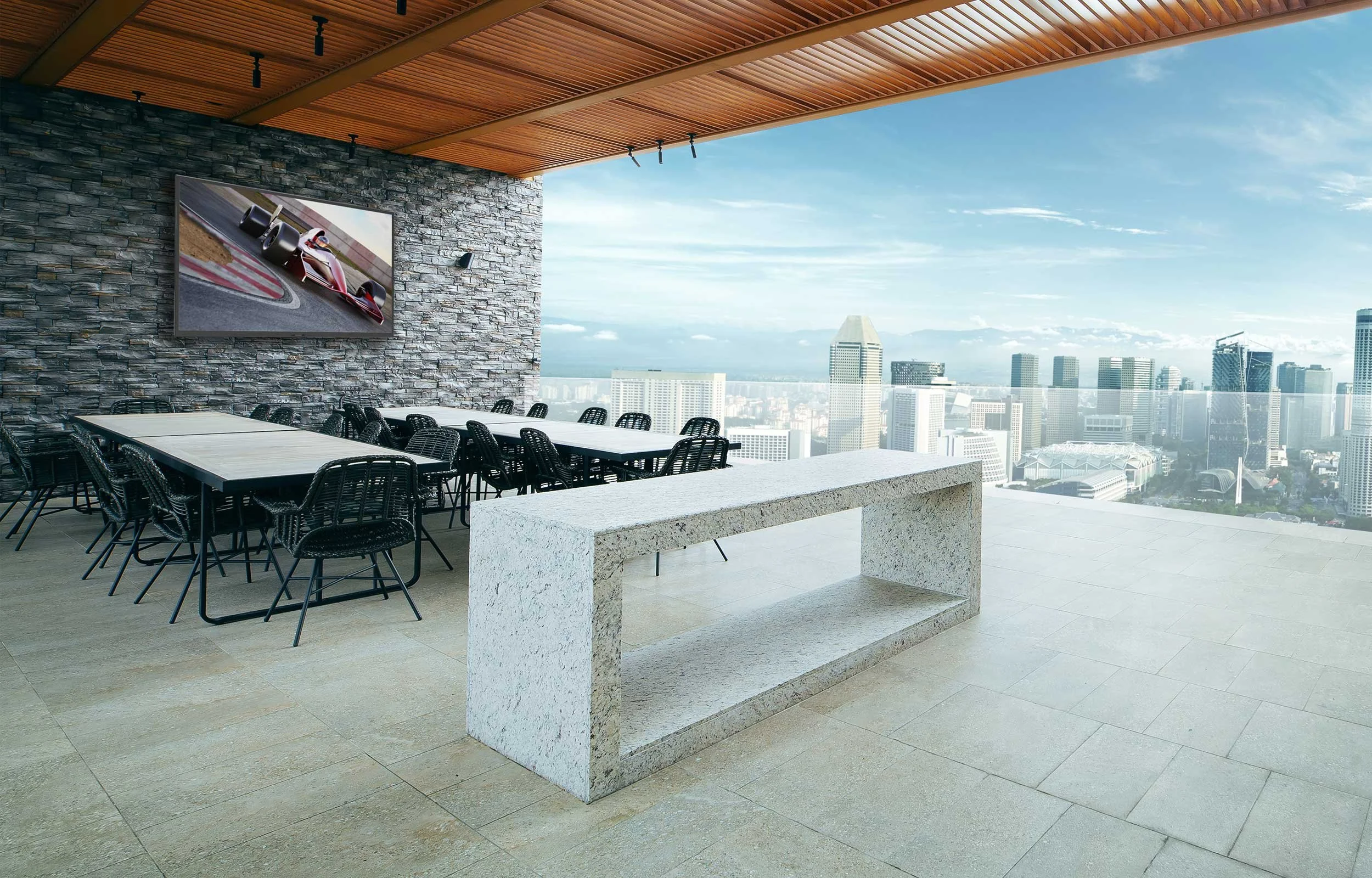 SunBrite outdoor TV on stone wall in modern rooftop entertaining space with city skyline view installed by VIP Smart Homes Seattle