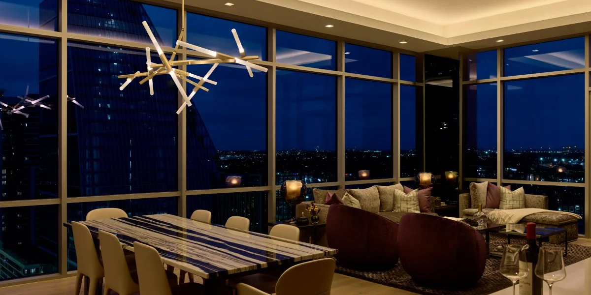 Lutron Ketra warm evening tunable light dining and living room with sputnik chandelier and city night view | VIP Smart Homes Seattle