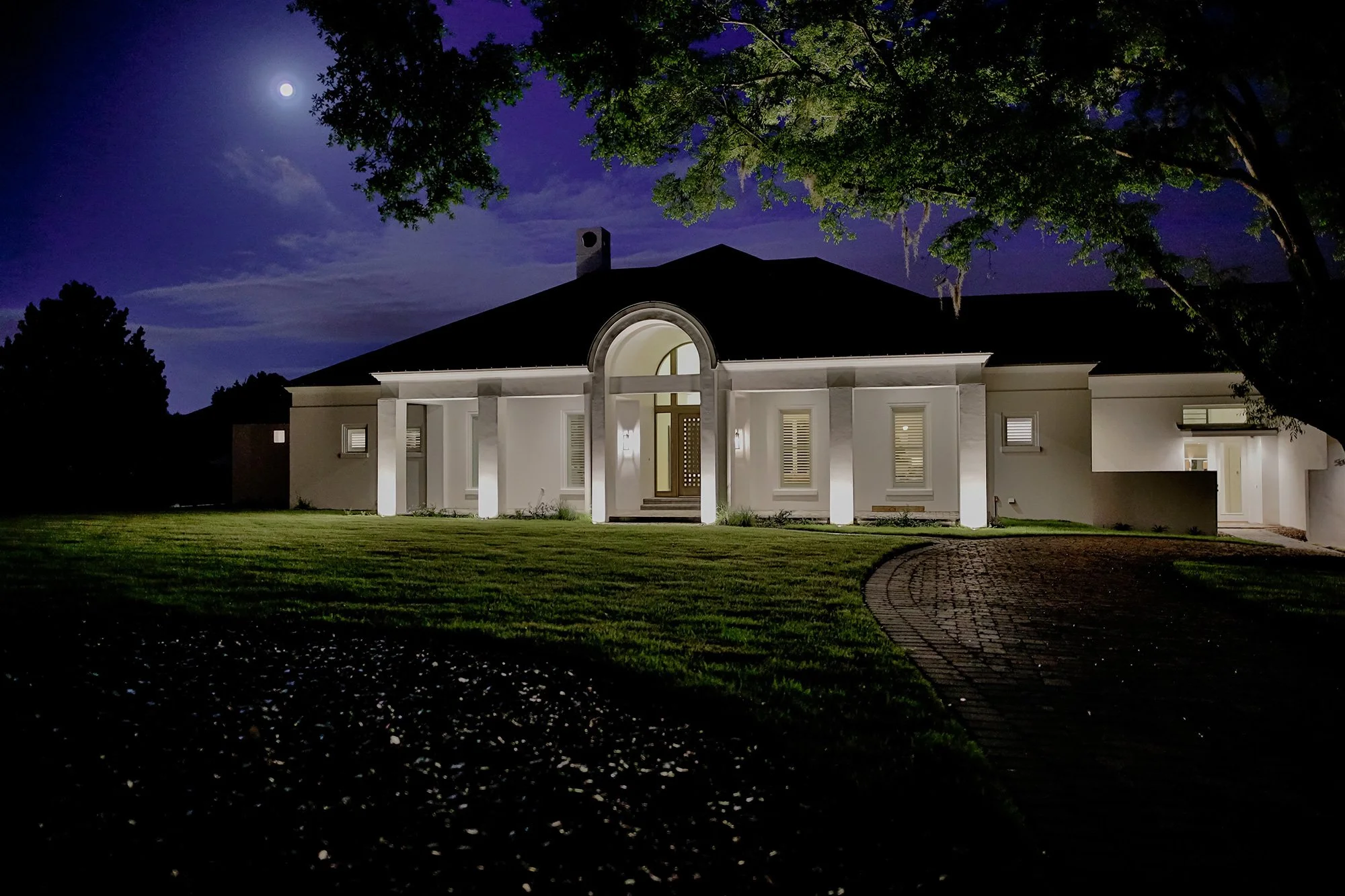 Luxury smart home illuminated at night with integrated Lutron landscape and architectural lighting | VIP Smart Homes Support Plans