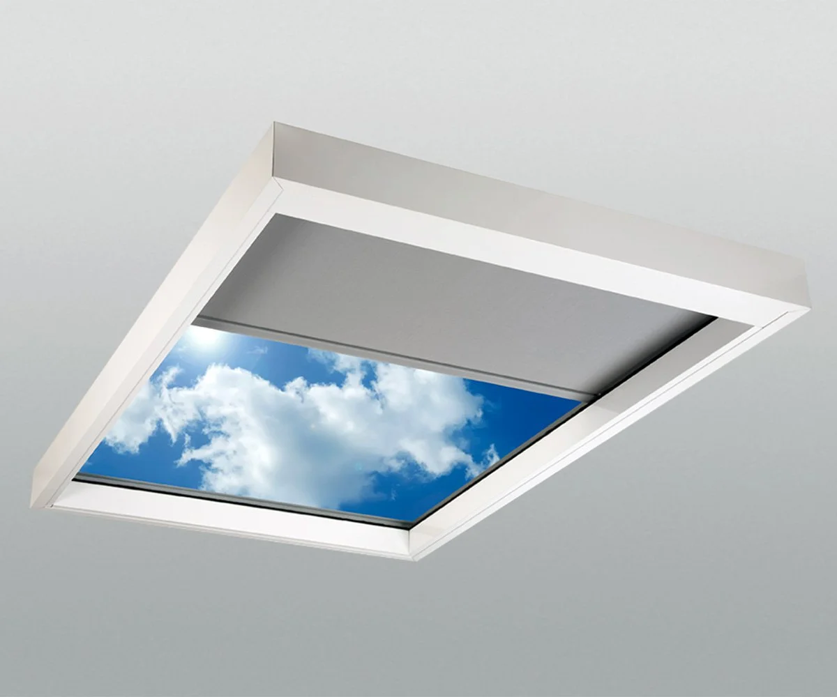 Lutron tensioned skylight shade with cable guided fabric system mounted in ceiling skylight showing partial deployment with sky visible