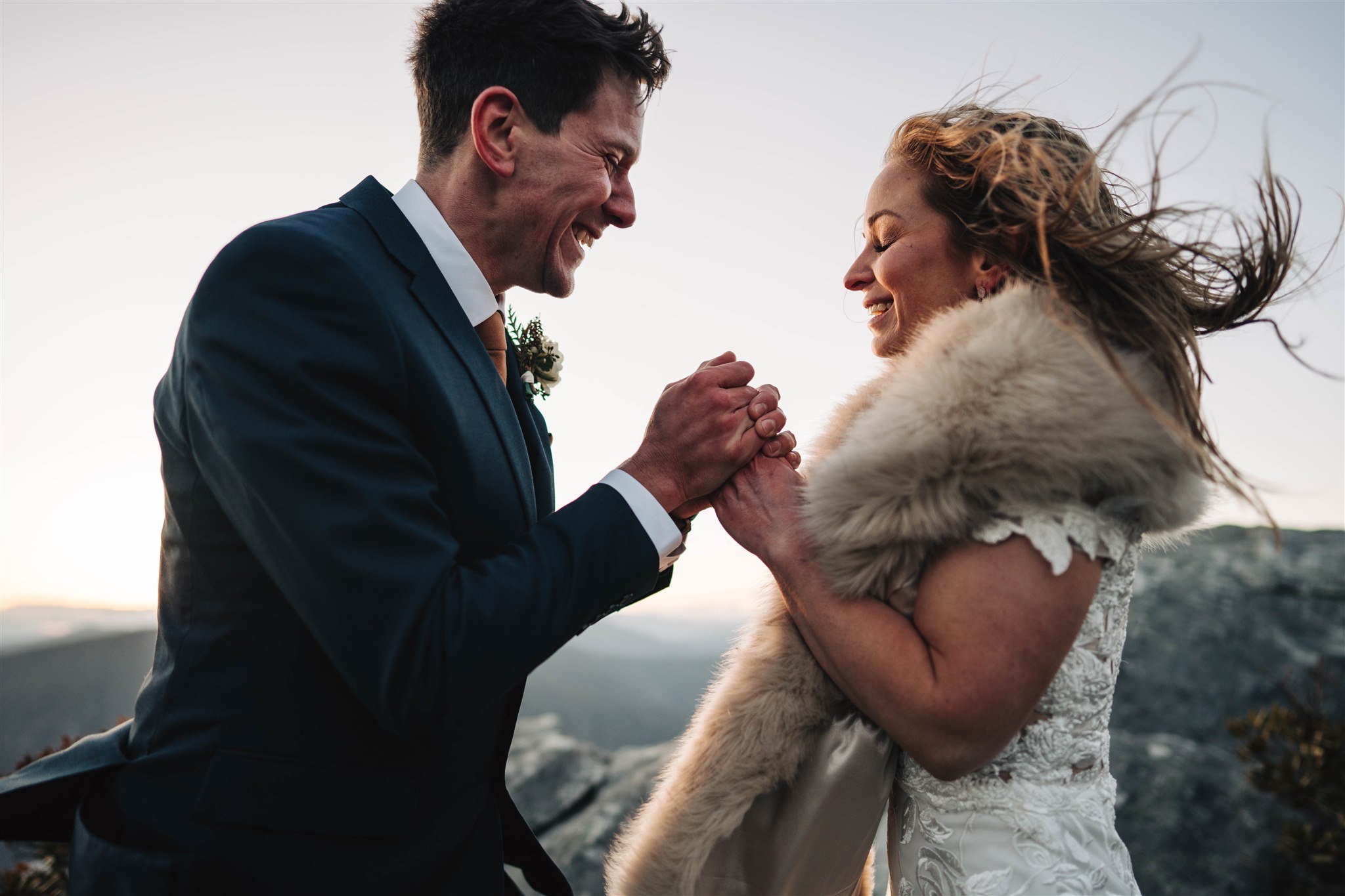 Couple on a windy mountain overlook during an outdoor wedding portrait
