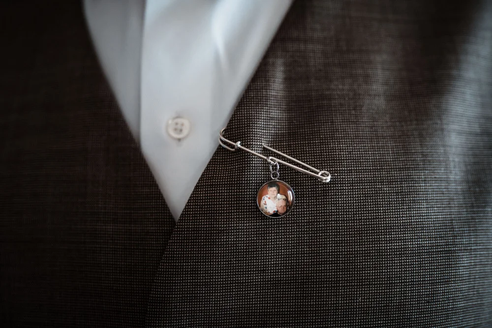 A meaningful photograph pin attached to Roland's wedding vest