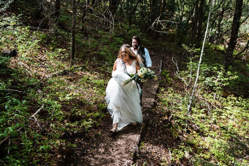Kimb and Roland walking through the forest on their wedding day near Brevard, North Carolina