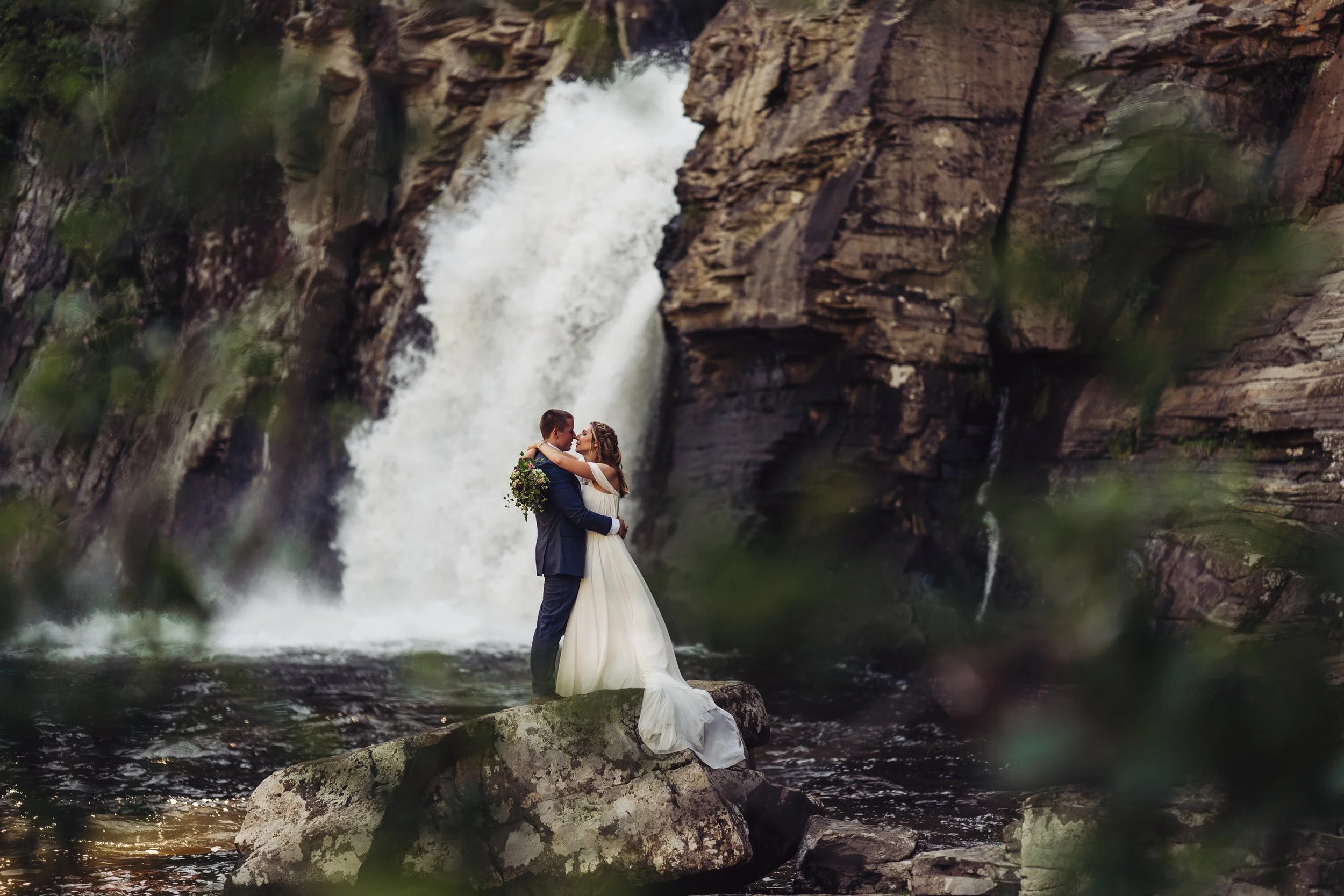 Couple together near a waterfall and forest setting in Western North Carolina