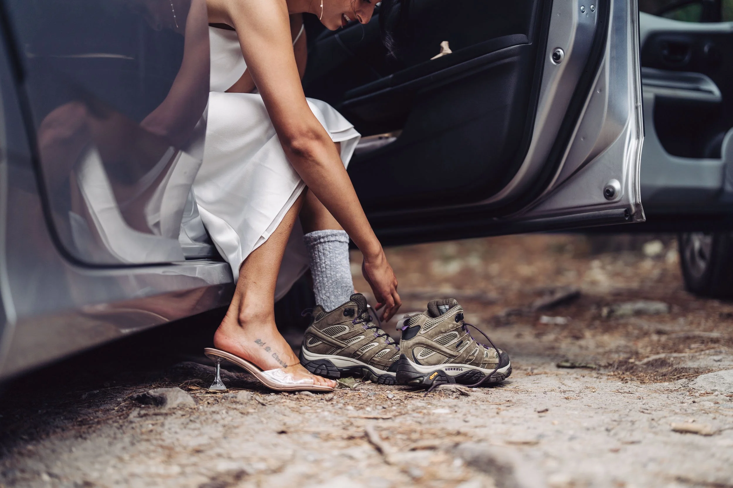 Bride wearing hiking boots with a wedding dress on a dirt trail