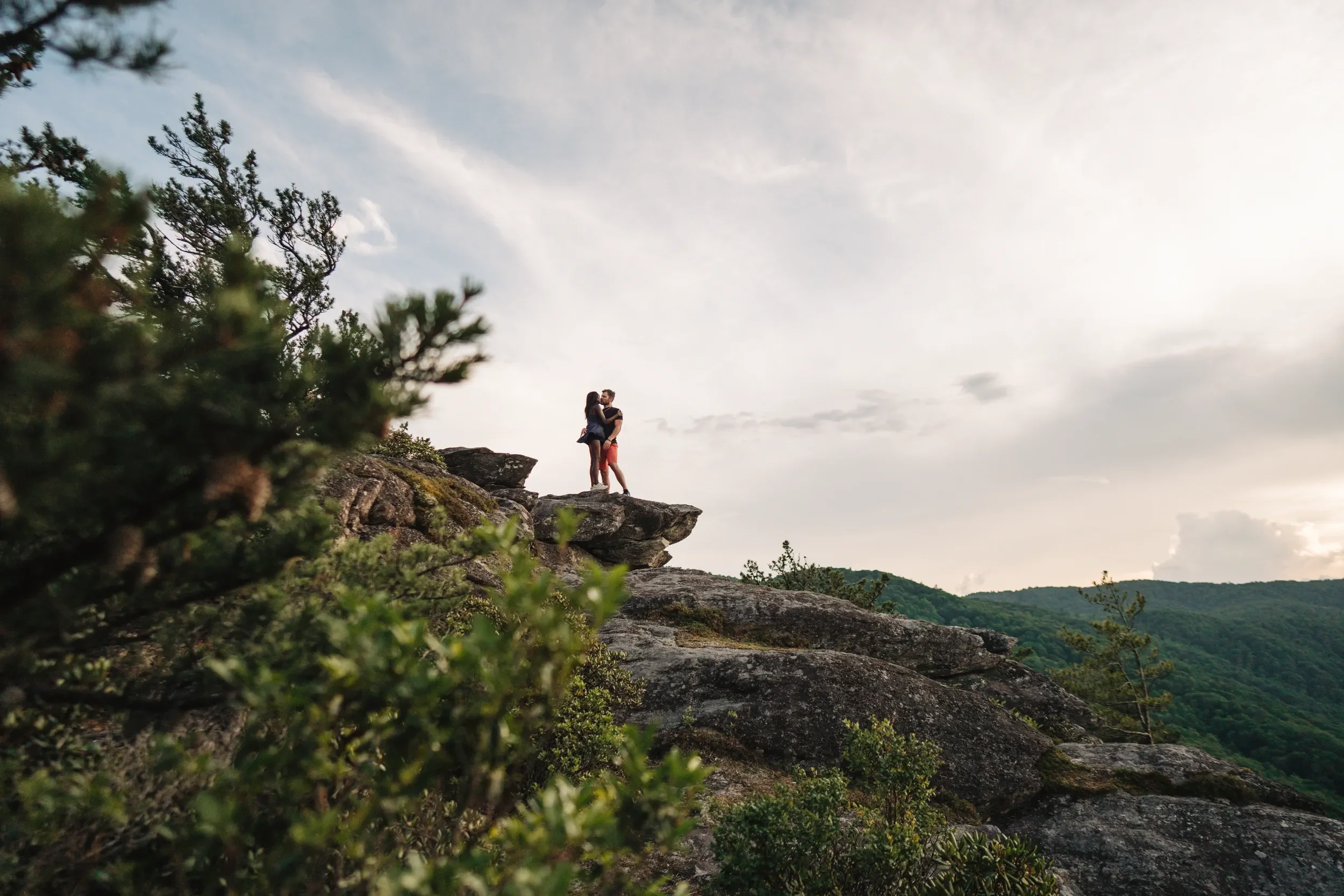 Newly engaged couple hugging after a mountain proposal