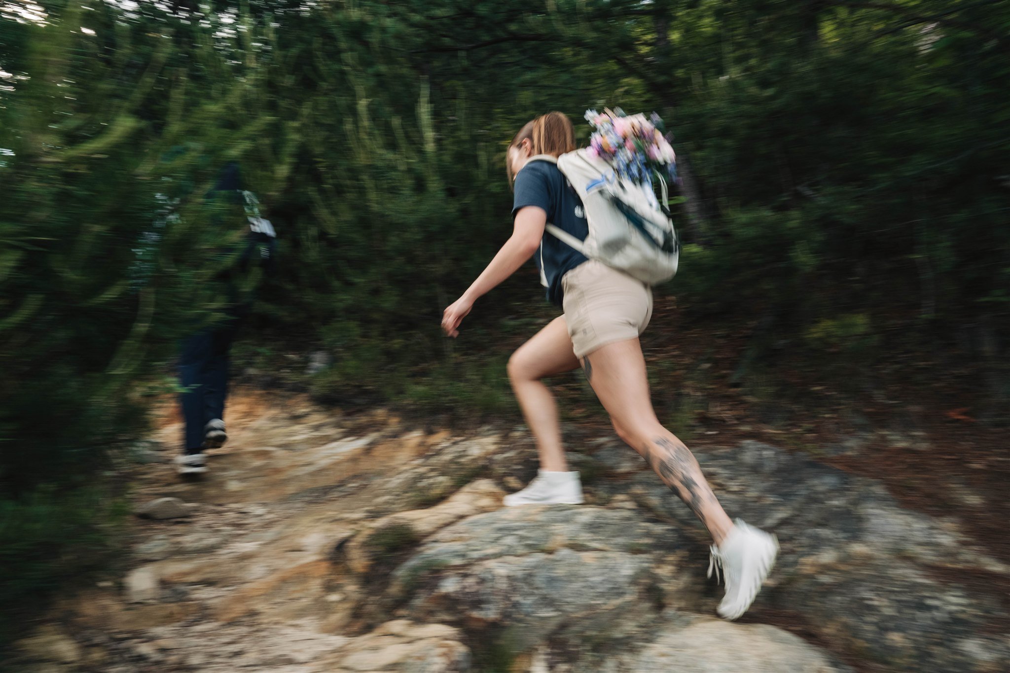 Woman hiking on a mountain trail with a backpack during an outdoor adventure elopement