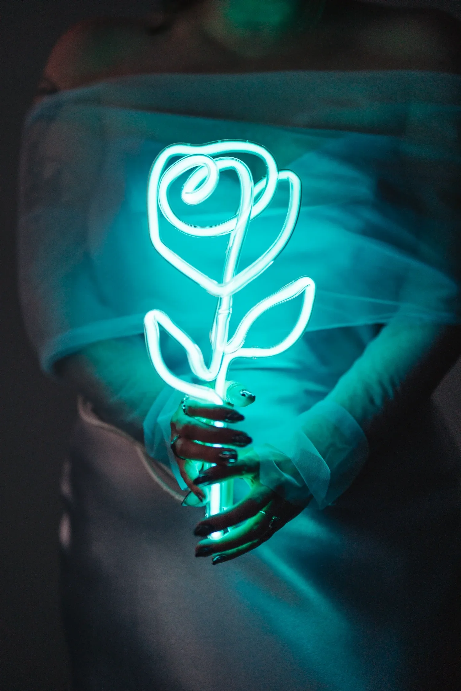 Bryanna and RJ with glowing neon flowers during blue hour at Hawksbill Mountain
