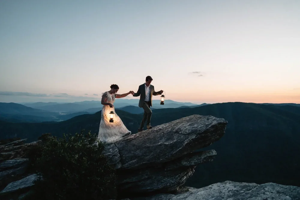 Mackenzie and Michael walking with lanterns after sunset on Hawksbill Mountain.