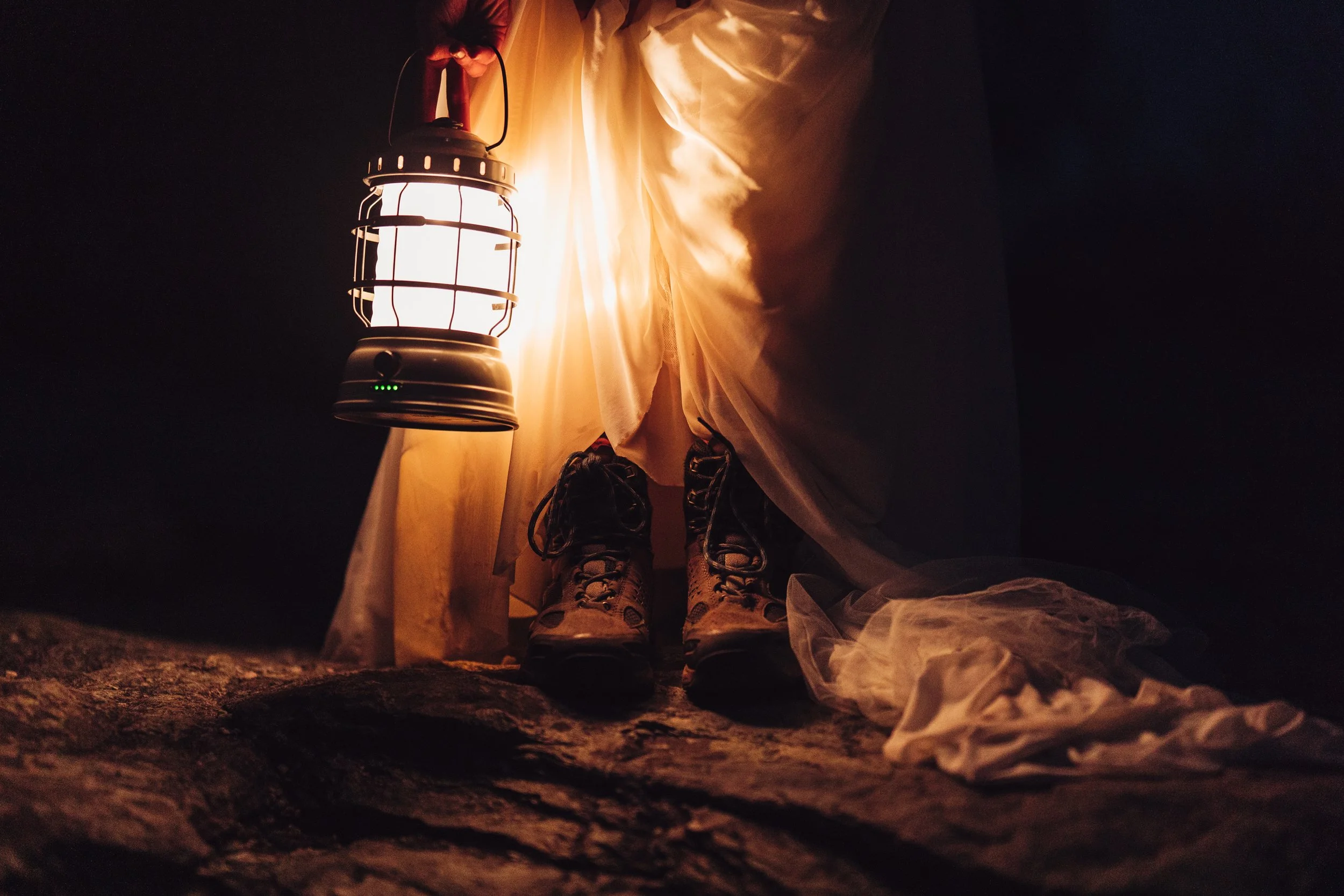 Wedding boots and lantern detail during a rustic nighttime elopement