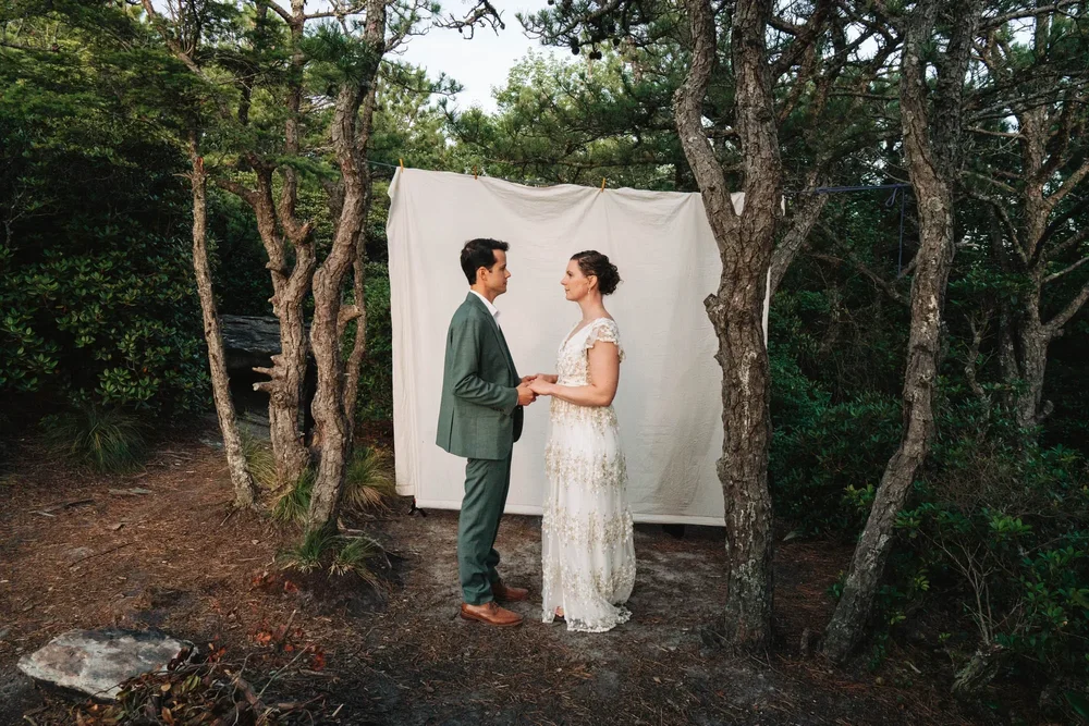 Mackenzie and Michael standing together during the Hawksbill portion of their mountain wedding day.