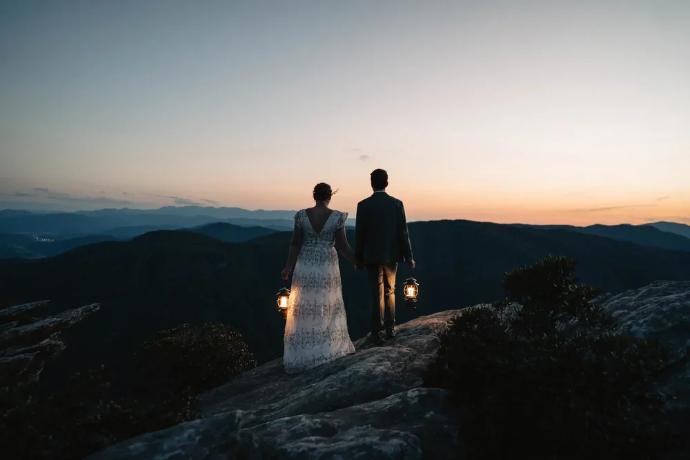Lantern-lit portrait of Mackenzie and Michael after sunset on Hawksbill Mountain.