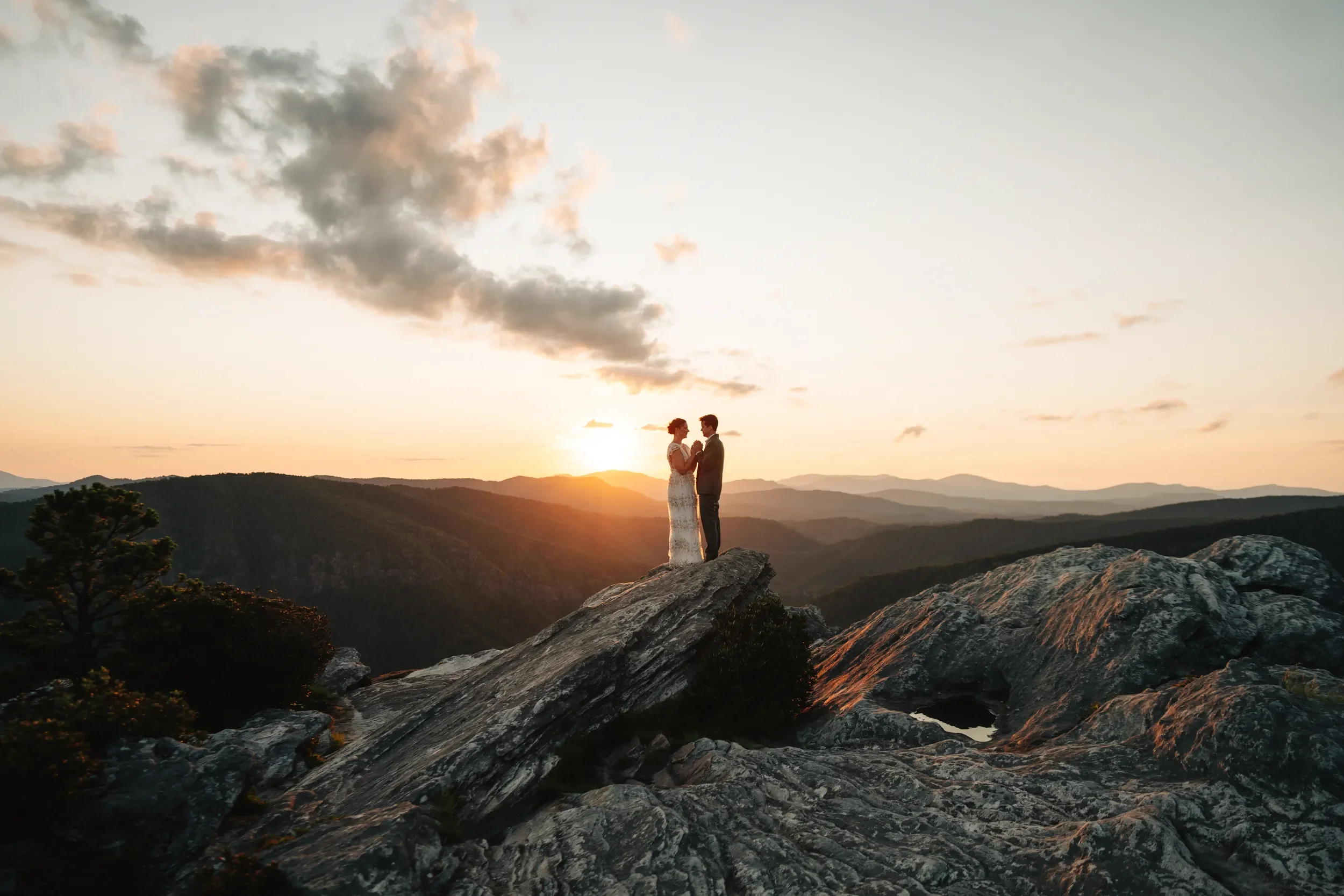 Mackenzie and Michael standing together on Hawksbill Mountain at sunset after their Wiseman's View wedding.