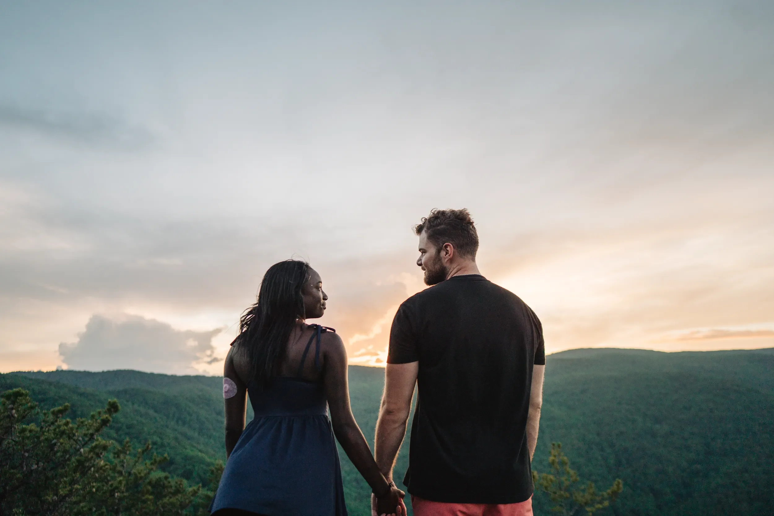 Newly engaged couple laughing together after a mountain proposal